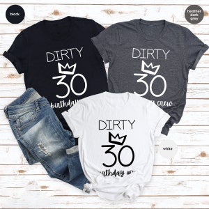 May include: Three t-shirts with the text "Dirty 30" and a crown design. The shirts are in black, heather dark grey, and white.