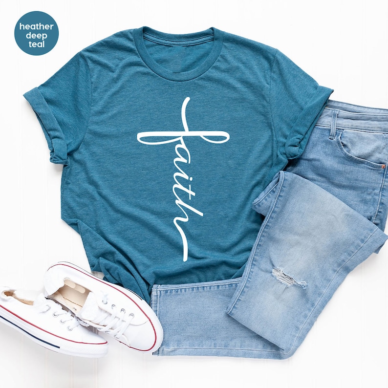 May include: A teal blue t-shirt with a white cross and the word "faith" written vertically on the cross.