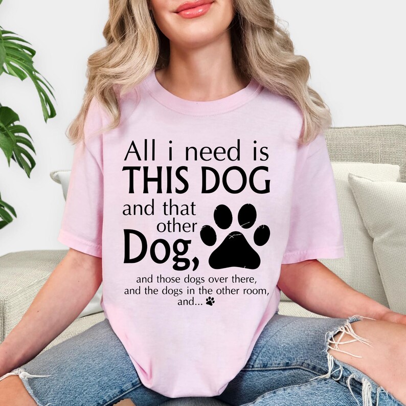 A woman wearing a pink t-shirt with a humorous text printed on it.