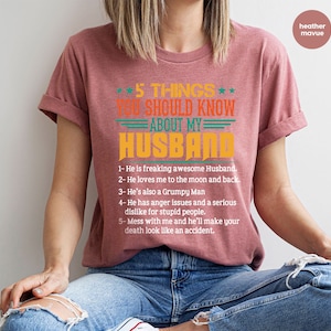 May include: A heather mauve t-shirt with the text "5 Things You Should Know About My Husband" in a retro font. The text is followed by a list of five humorous statements about a husband.