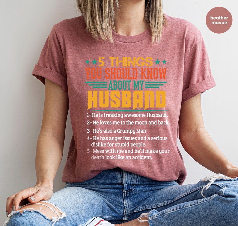 May include: A heather mauve t-shirt with the text "5 Things You Should Know About My Husband" in a retro font. The text is followed by a list of five humorous statements about a husband.