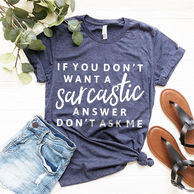 May include: A navy blue t-shirt with white text that reads "If you don't want a sarcastic answer don't ask me".