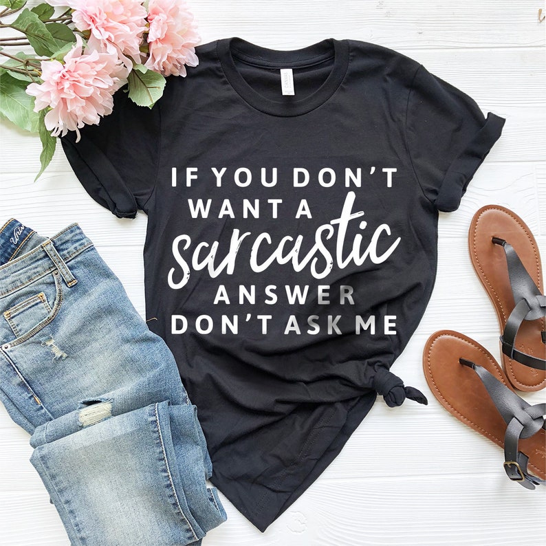 May include: Black t-shirt with white text that reads "If you don't want a sarcastic answer don't ask me".