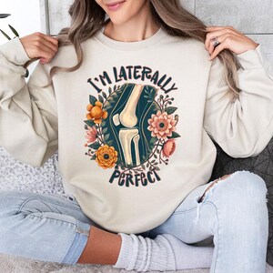 a woman sitting on a couch wearing a sweatshirt