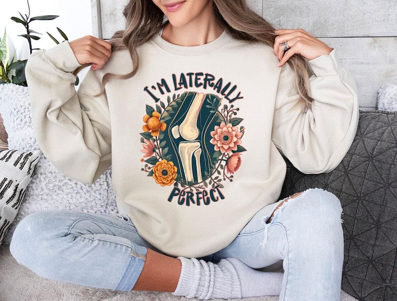 a woman sitting on a couch wearing a sweatshirt