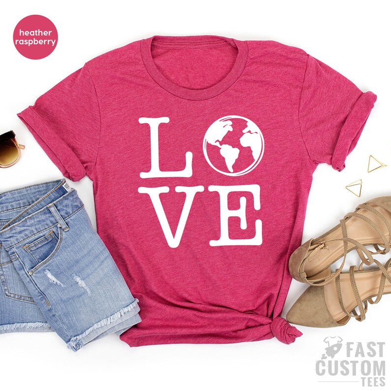 May include: A heather raspberry t-shirt with the word "LOVE" in white text with a white outline. The "O" in LOVE is replaced with a white outline of the Earth.