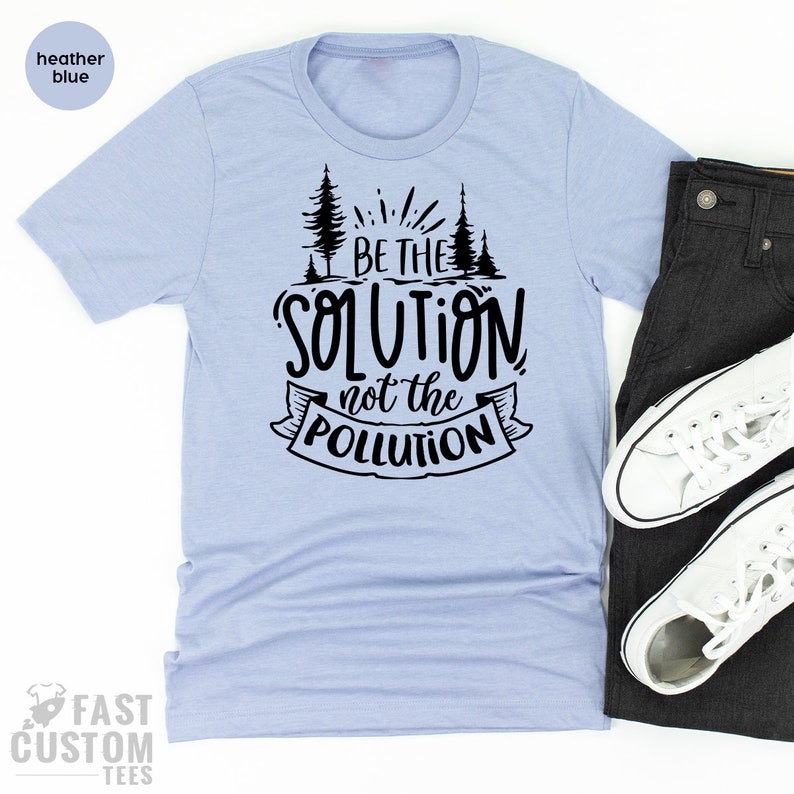 May include: A light blue t-shirt with a black graphic that reads "Be the solution not the pollution". The graphic also includes a stylized image of trees.