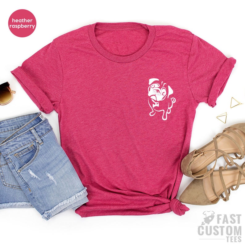 May include: A heather raspberry t-shirt with a white pug graphic on the front. The shirt is made of a soft, comfortable material and is perfect for everyday wear.