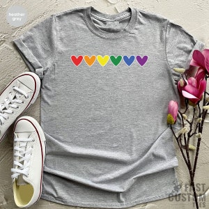 May include: Heather grey t-shirt with a row of rainbow coloured hearts.
