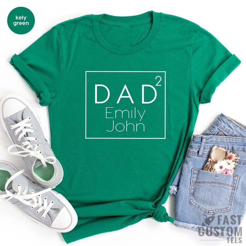 May include: A kelly green t-shirt with a white square graphic that says "DAD&sup2; Emily John"