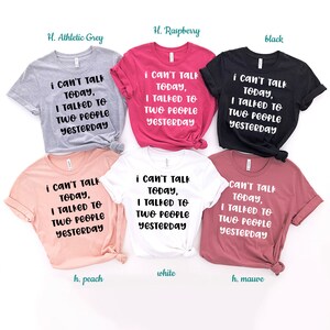 May include: Six t-shirts in different colors with the text "i can't talk today, I talked to two people yesterday" printed on the front. The colors are athletic grey, raspberry, black, peach, white, and mauve.