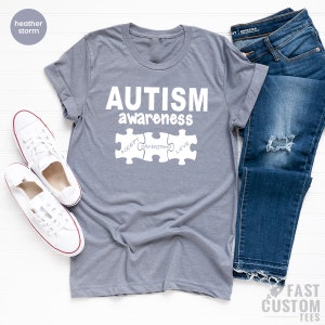 May include: A heather storm grey t-shirt with the text "AUTISM awareness" and three puzzle pieces that say "ACCEPT", "UNDERSTAND", and "LOVE".