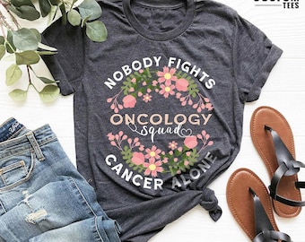 Camiseta del equipo de oncología, camiseta "Nadie se enfrenta al cáncer solo", camiseta del equipo de oncología, camiseta de enfermera de oncología, camiseta de enfermera de atención oncológica
