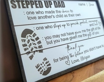 May include: A wooden sign with the text "Stepped Up Dad" and a message about the importance of being a stepparent. The sign features two footprints and the text "name | Dean" and "Love, Morgan".