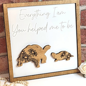 May include: Wooden sign with the text "Everything I am you helped me to be" and two wooden turtles with floral designs.