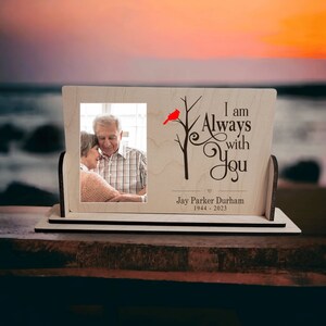 May include: A wooden picture frame with a photo of a couple, a red cardinal on a branch, and the text "I am Always with You" with the name "Jay Parker Durham" and the dates "1944 - 2023".