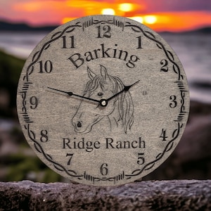May include: A gray wooden clock with a horse silhouette and barbed wire design. The clock face reads "Barking Ridge Ranch" and has black hands and numbers.