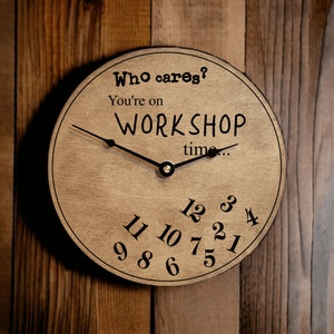 May include: A brown wooden clock with black hands and black numbers. The clock face has the text "Who cares? You're on WORKSHOP time..."