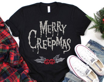 May include: Black t-shirt with the text "Merry Creepmas" in a dripping font. The text is in white with a red skull and crossbones graphic below it.