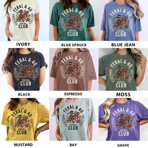 May include: A collection of t-shirts in various colors, each featuring a circular graphic with the text "FERAL & 40 SOCIAL CLUB" and a tiger illustration. Colors include ivory, blue spruce, blue jean, black, espresso, moss, mustard, bay, and grape.