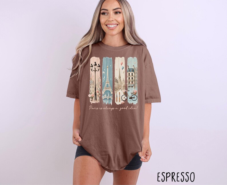 May include: A brown oversized t-shirt with a graphic print of Parisian landmarks and the text "Paris is always a good idea!"
