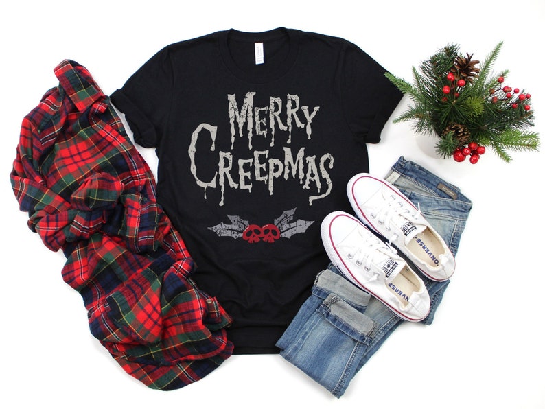 May include: Black t-shirt with the text "Merry Creepmas" in a dripping font. The text is in white with a red skull and crossbones graphic below it.