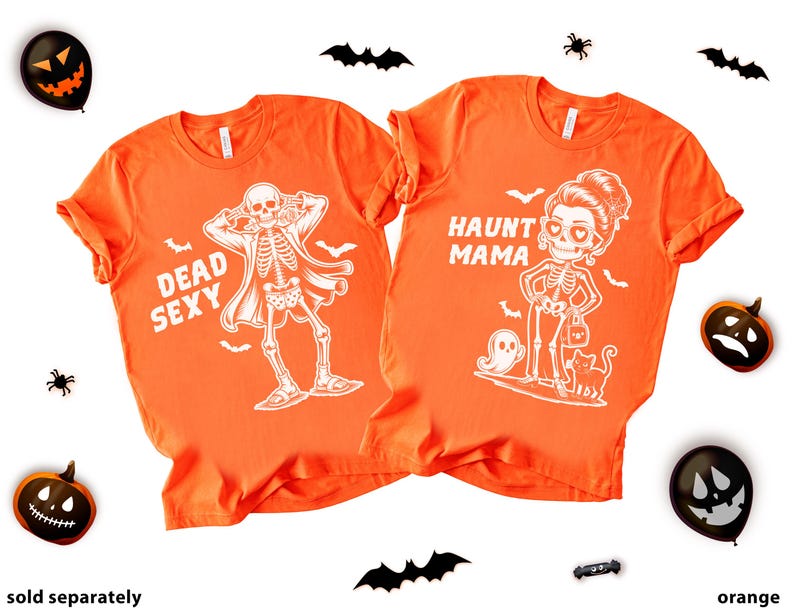 K&ouml;nnte beinhalten: Zwei orangefarbene T-Shirts mit Halloween-Designs. Eines zeigt ein Skelett und den Text "Dead Sexy". Das andere sagt "Haunt Mama" mit einer Skelettfrau, einem Geist und einer Katze. Halloween-Dekorationen umgeben die Shirts.