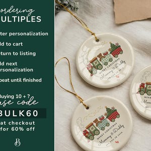 May include: Three round ceramic Christmas ornaments with gold string. Each ornament features a train design with teddy bears and the text "Merry Christmas Mommy & Daddy". The ornaments are cream-colored.