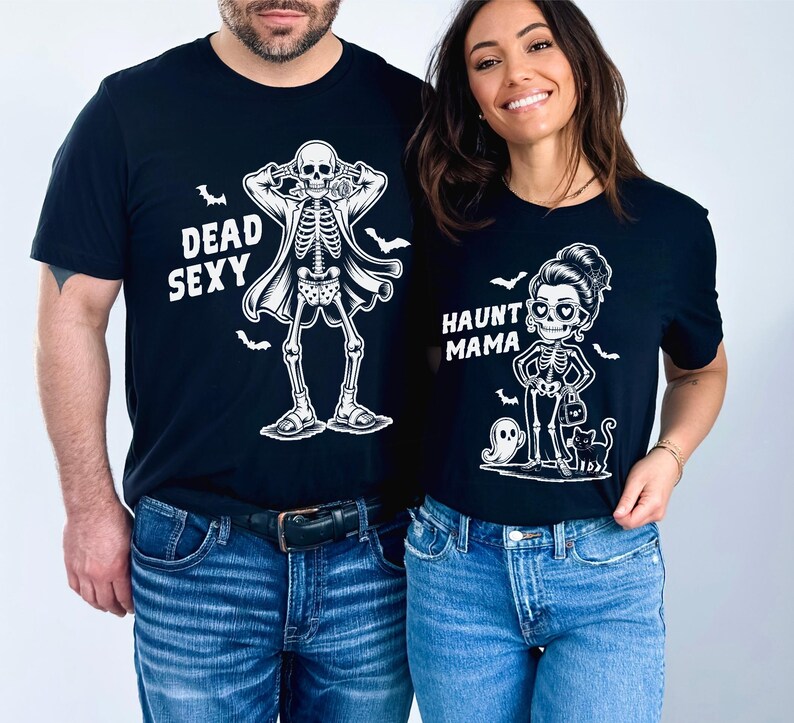K&ouml;nnte beinhalten: Schwarze T-Shirts mit Halloween-Skelett-Designs. Eines zeigt ein Skelett mit Mantel und dem Text "DEAD SEXY". Das andere zeigt ein Skelett mit Handtasche, Geist und Katze mit dem Text "HAUNT MAMA".