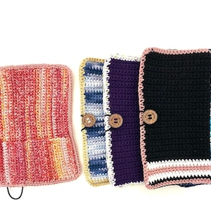 May include: A collection of handmade crochet items in various colors. The items include a multi-colored pouch with pockets and several rectangular cases with wooden button closures. Colors include pink, blue, black, and gold.