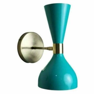 May include: A teal-colored wall sconce with a brass-colored mounting plate and arm. The sconce has a unique hourglass shape with a gold band. The light fixture is a modern design.