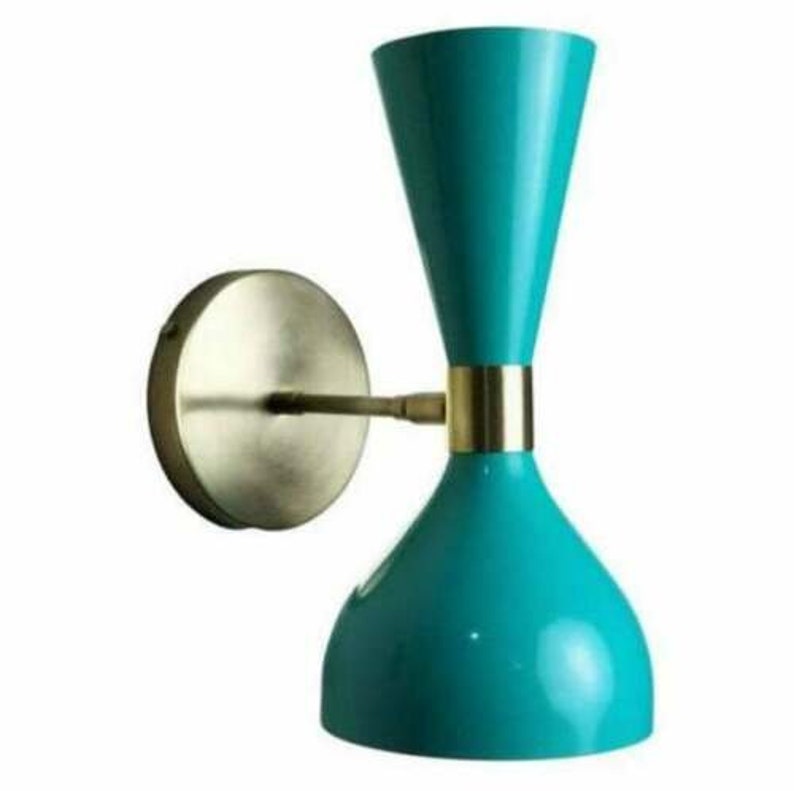 May include: A teal-colored wall sconce with a brass-colored mounting plate and arm. The sconce has a unique hourglass shape with a gold band. The light fixture is a modern design.