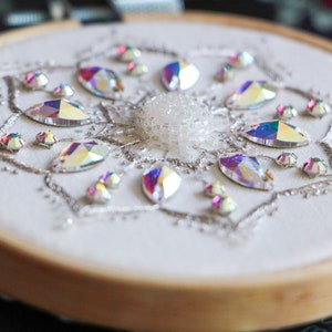 A close up bottom side view of the hoop shows the 3D profile of the beads and central cabochon for the Crystal Snowflake bead embroidery pattern.