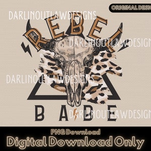Può includere: Un design grafico scaricabile digitalmente che presenta un triangolo nero con le parole "Rebel Babe" in testo marrone. Il triangolo è sovrapposto a una stampa animalier marrone e bianca e un teschio con corna. Il testo "Darlin Outlaw Designs" appare in testo marrone nella parte superiore e inferiore del design.