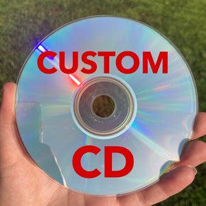 May include: A blank silver CD with the words "CUSTOM CD" printed in red on the surface.