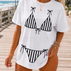 May include: White t-shirt featuring a black and white striped bikini design. The design includes a bikini top and bottom with bow details. The image also includes the text "SVG - PNG (300 DPI) - DXF".