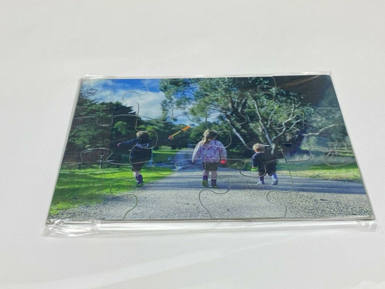 Puede incluir: Un rompecabezas de fotos con tres ni&ntilde;os caminando por un sendero en un parque. Los ni&ntilde;os visten ropa informal y caminan en fila. El rompecabezas est&aacute; hecho de cart&oacute;n y tiene un acabado brillante.
