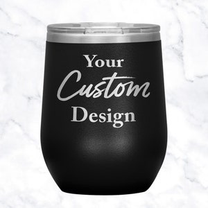 以下が含まれることがあります： 「Your Custom Design」と銀色の文字が刻まれた、黒いステンレス製のワインタンブラーです。