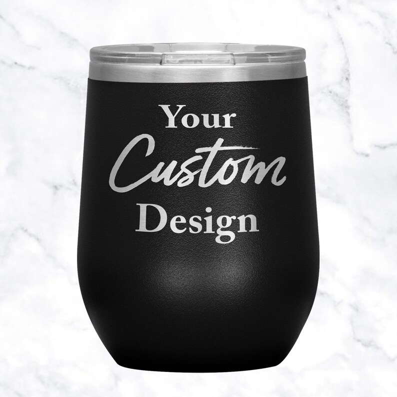 以下が含まれることがあります： 「Your Custom Design」と銀色の文字が刻まれた、黒いステンレス製のワインタンブラーです。