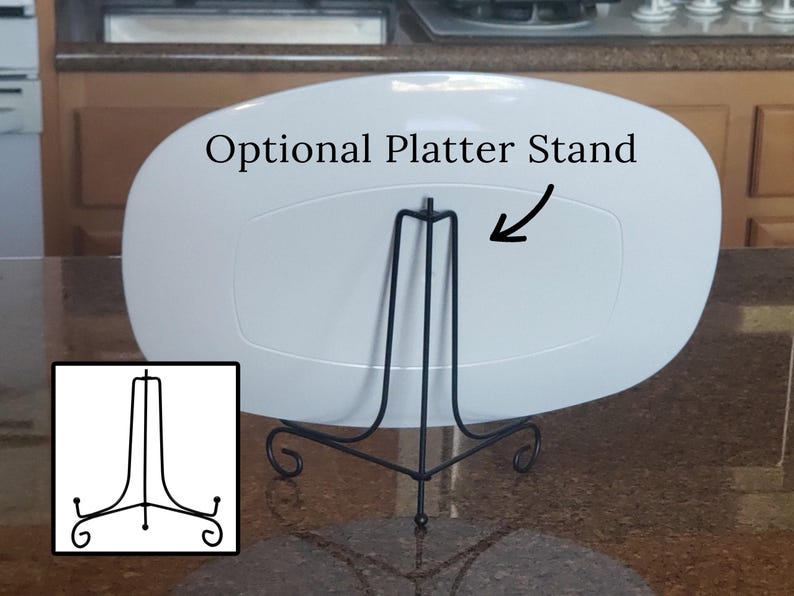May include: White oval platter with an optional black metal stand. The stand has three legs with a decorative scroll design. The text "Optional Platter Stand" is written above the stand.