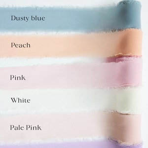 May include: Image of ribbon color options. The image displays six different ribbon colors: dusty blue, peach, pink, white, pale pink, and purple. The text "Ribbon Color Options" is at the top of the image. Each ribbon has a frayed edge.