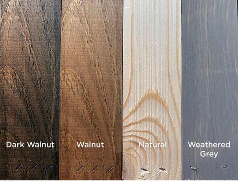May include: A collection of four wood stain samples: Dark Walnut, Walnut, Natural, and Weathered Grey. Each sample is a vertical plank with visible wood grain and the stain name printed below. The samples are arranged side by side.