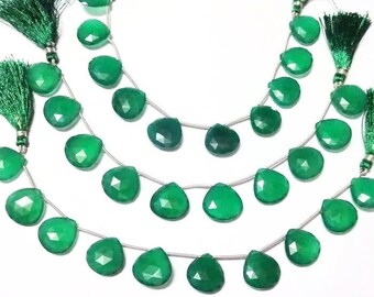 Puede incluir: Una hebra de cuentas de piedras preciosas verdes con gotas facetadas, enhebradas en un alambre de plata. Las cuentas están separadas por pequeños separadores de plata. La hebra está terminada con acentos de borlas verdes.