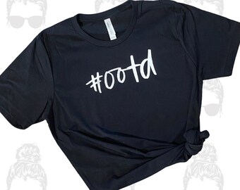 May include: Black t-shirt with white text that says "#OOTD".