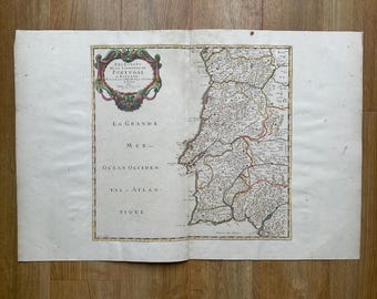 May include: An antique map of Portugal, featuring detailed cartography and text in French. The map is framed by an ornate decorative border with a title cartouche. The map is printed on aged paper, showing signs of wear.