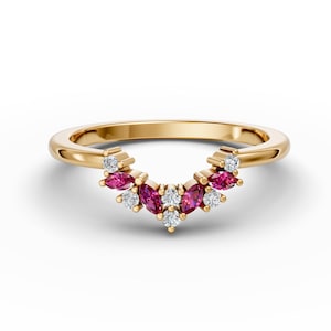May include: A gold band ring with a curved design featuring a row of marquise-shaped ruby and round diamonds.