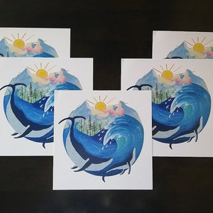 May include: Five white cards with a watercolor illustration of a whale jumping out of the water with a mountain range and sun in the background. The whale is blue and the water is a light blue with white foam.