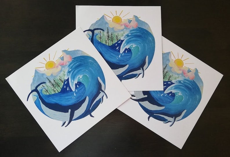 May include: Three watercolor prints of a blue wave crashing over a mountain range with a yellow sun and pink clouds in the sky.  Three whales are swimming in the wave.