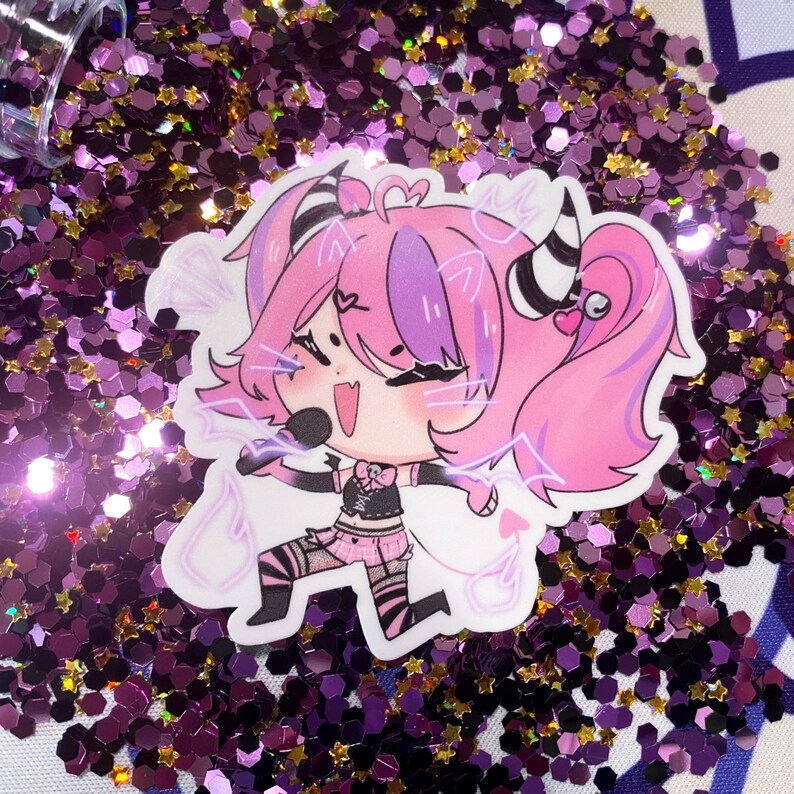 May include: A pink and purple cartoon character with black and white striped horns and a tail. The character is singing into a microphone and has a pink heart on its cheek. The character is on a background of purple and gold glitter.