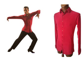 May include: A long-sleeved, button-down shirt in a vibrant red colour. The shirt features a classic collar, a front button placket with matching red buttons, and fitted sleeves with cuffs. The fabric appears smooth and lightweight, designed for movement.